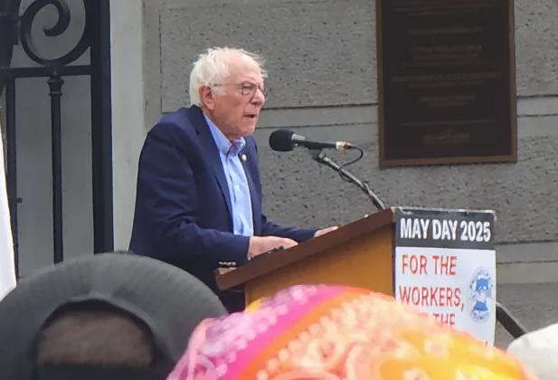 Disheveled old man with lots of energy stands in front of a microphone and lets loose on the evils of capitalism