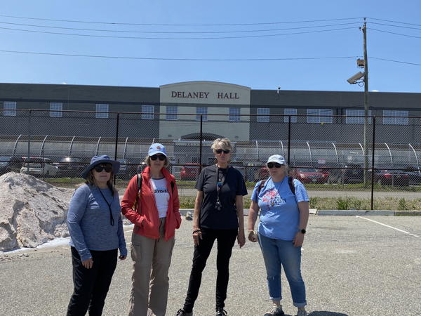 Four members of Cooper River Indivisible stand outside Delaney Hall